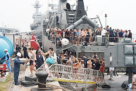 Tourists disembark from the HTMS Sukhothai in Sattahip after being rescued from flood-ravaged resorts in Koh Tao and Koh Phangan. Royal Thai Navy ships rescued more than 800 tourists who had been stranded there during the recent foul weather.